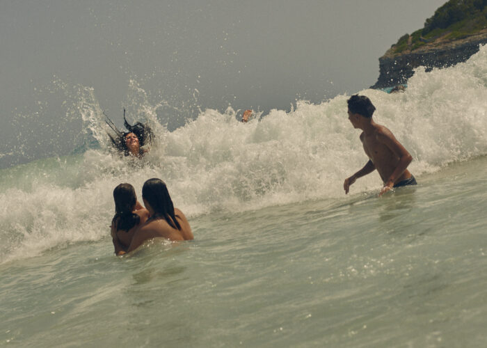 Lifestyle image of people playing in breaking waves.