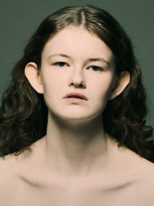 Close-up beauty portrait of young woman with curly hair.