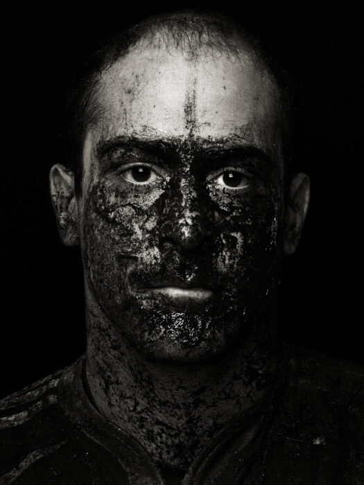 Beauty portrait of rugby man's face covered in mud.